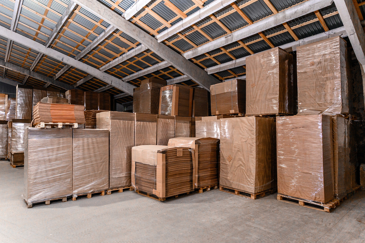 Склад с паллетами гофрокартона и листового картона, упакованными для хранения