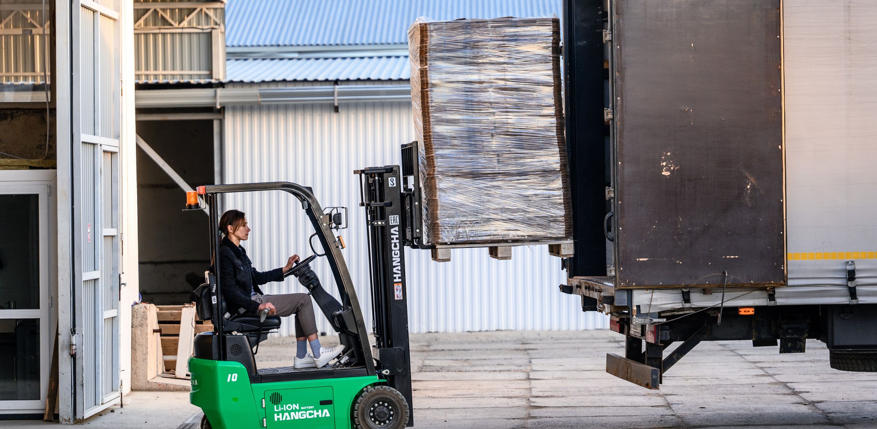 Процесс погрузки паллет с картоном на складе картонного завода
